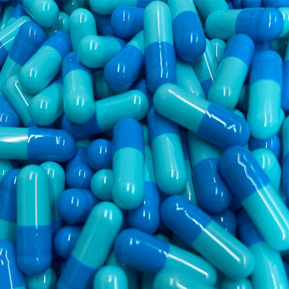 A photograph of empty gelatin capsules in light and dark blue colors.